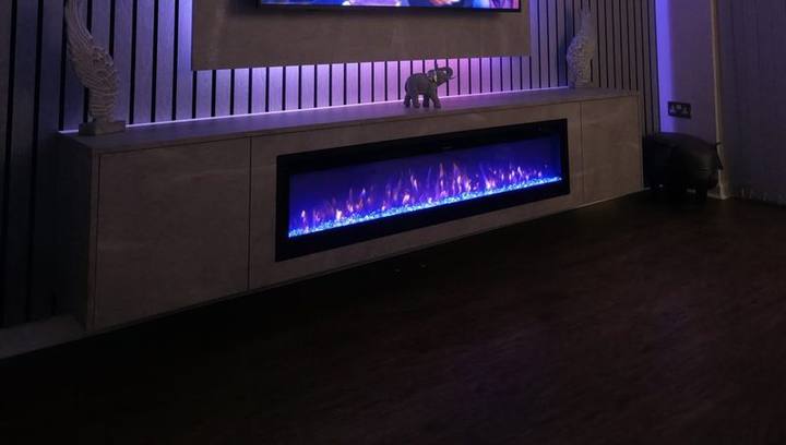 LED-lit media wall backpanel glowing purple above a crystal electric fire