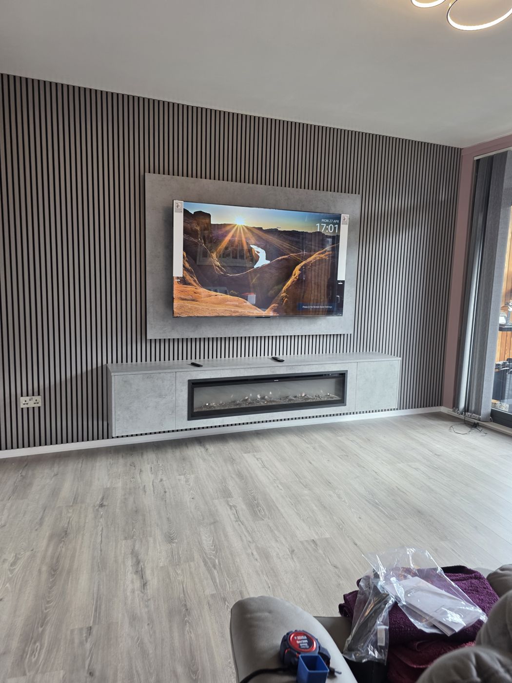 Glasgow media wall, light grey concrete panel, grey slats and long floating cabinet with electric fire below the TV.