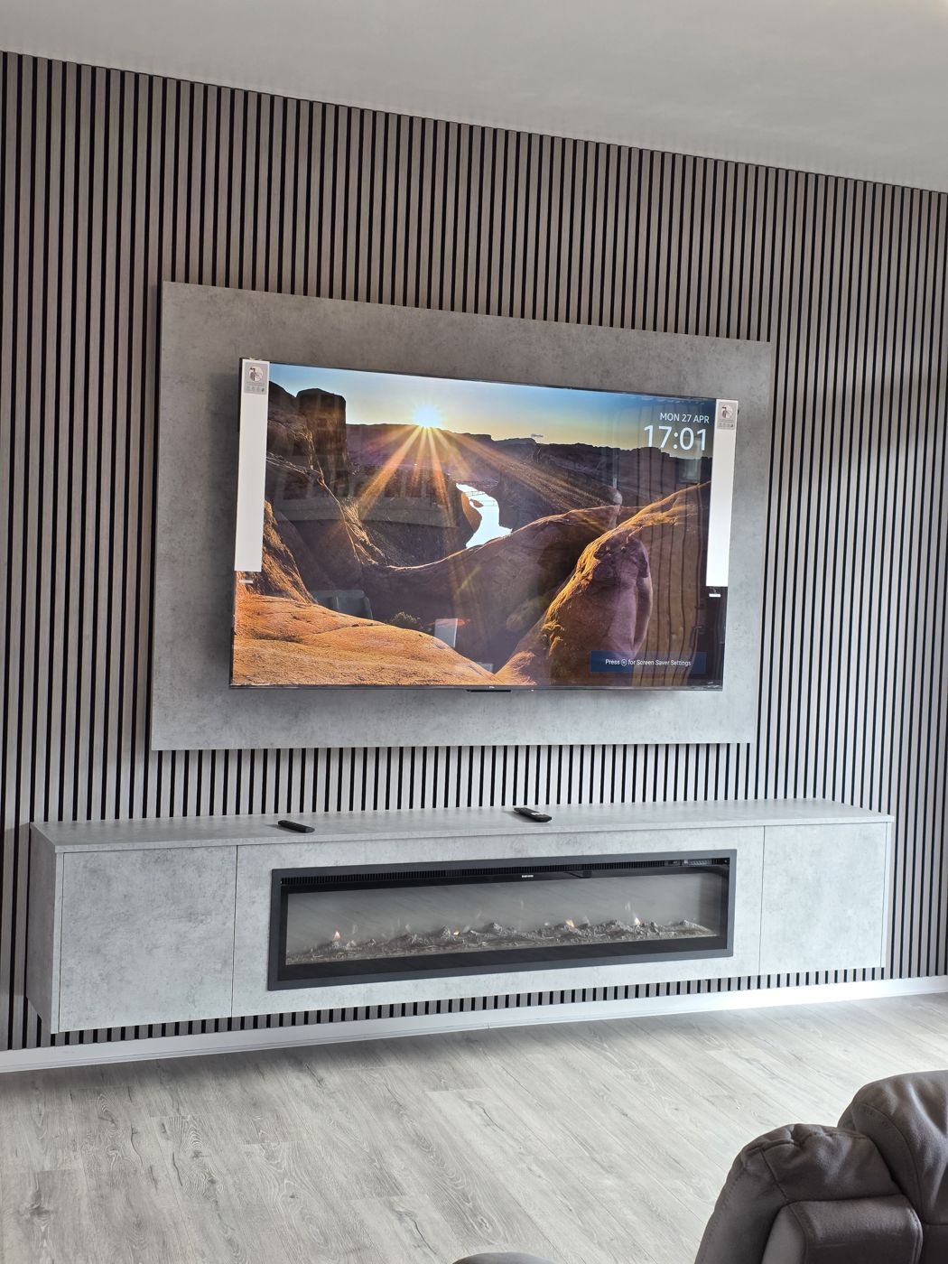 Close view of Glasgow grey concrete media wall, grey slats and long electric fire in the floating cabinet below.