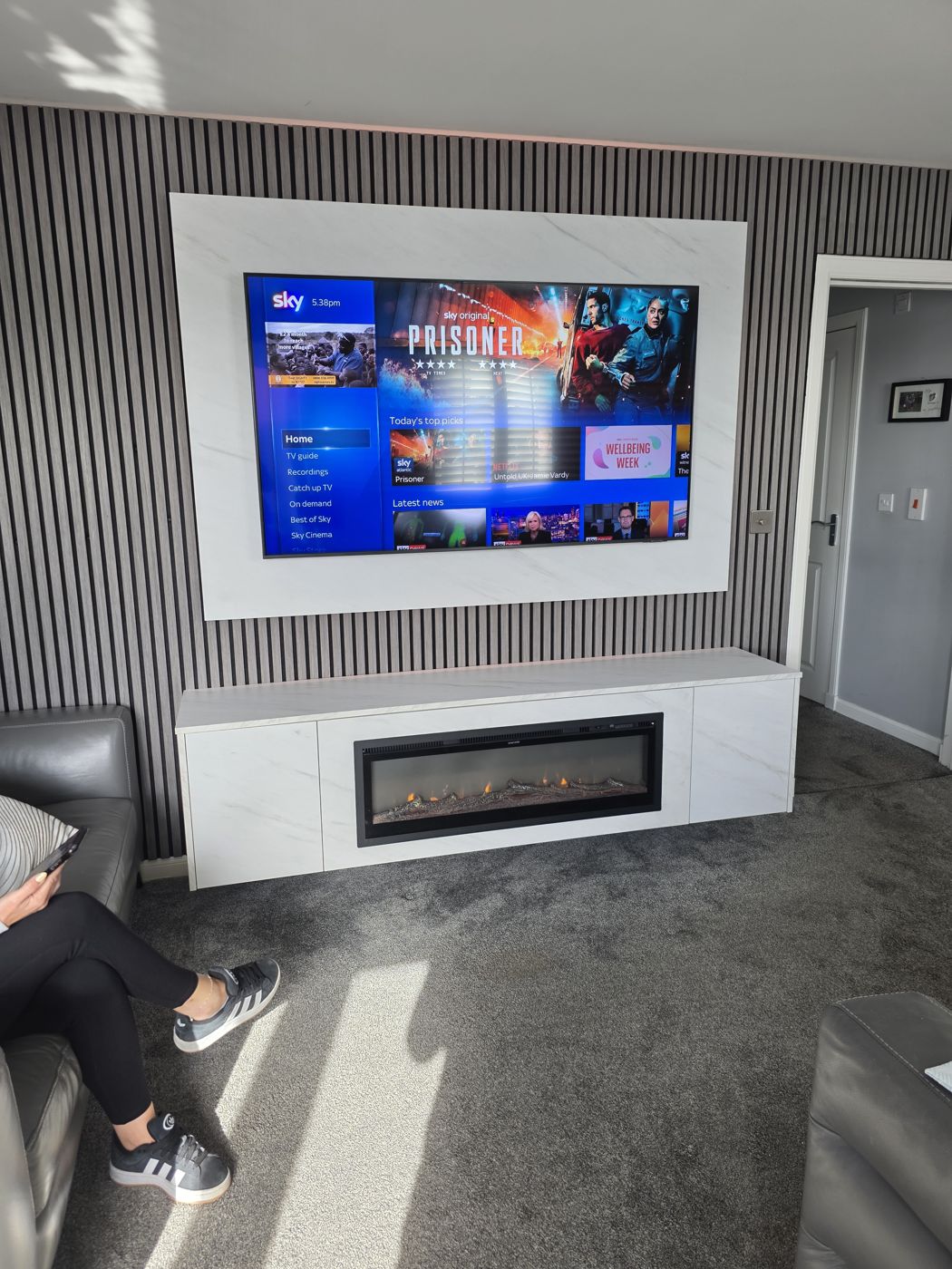 Glasgow media wall, white marble panel, grey slats and long white marble cabinet with electric fire below the TV.