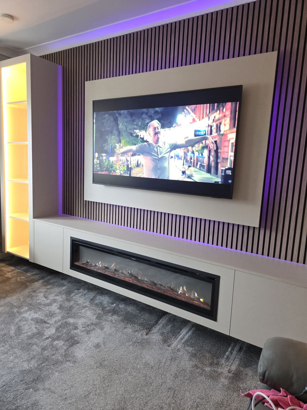Lanarkshire media wall, cream panel, oak slats, purple LED, amber-lit display cabinet and long electric fire below the TV.