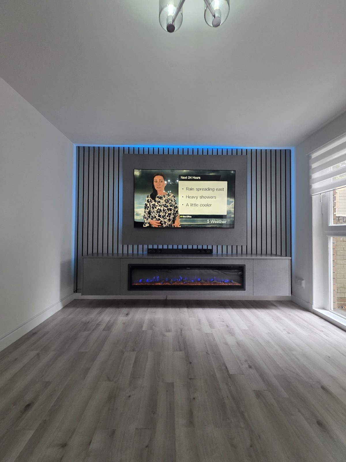Cubanite grey concrete media wall fitted in Glasgow with charcoal slats, blue LED backlighting and a blue-flame electric fire, by MPS Media Walls.