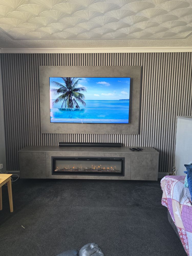 Front view of the dark grey Chicago concrete media wall in Girvan, framed TV panel, soundbar and amber electric fire, by MPS Media Walls.