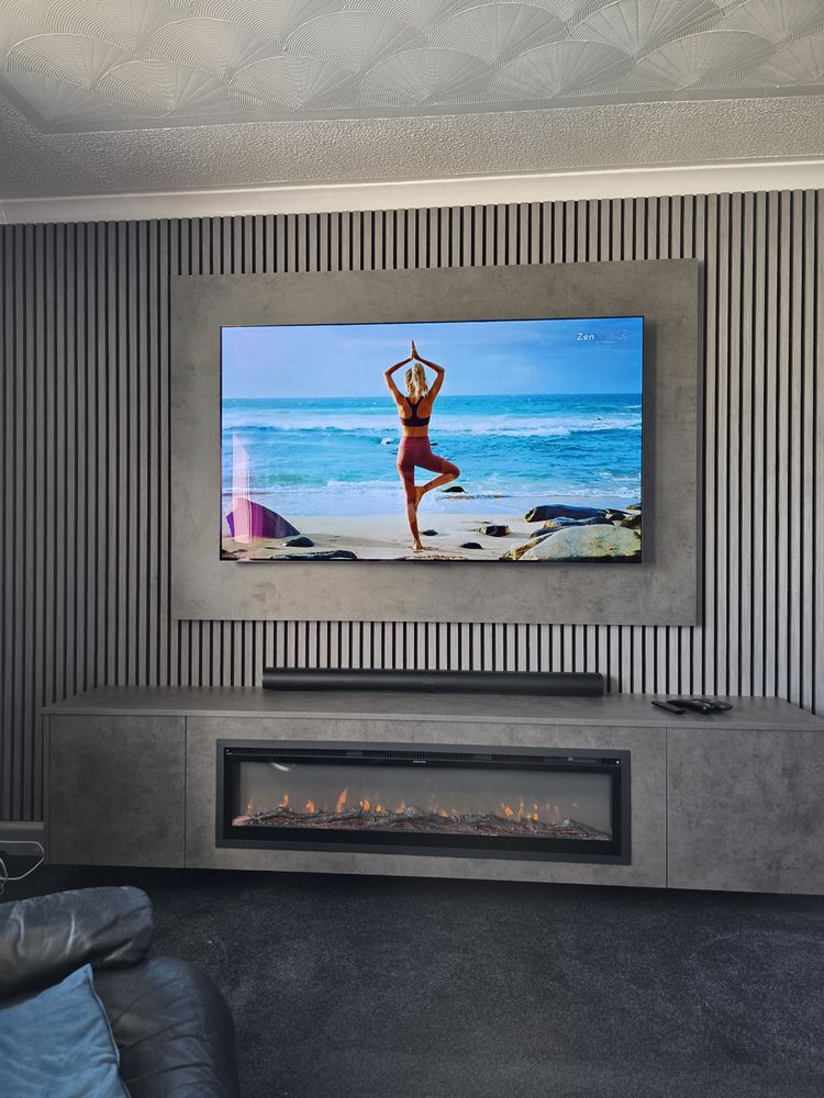 Side angle of the dark grey Chicago concrete cabinet and electric fire in Girvan, slatted wall and soundbar, by MPS Media Walls.
