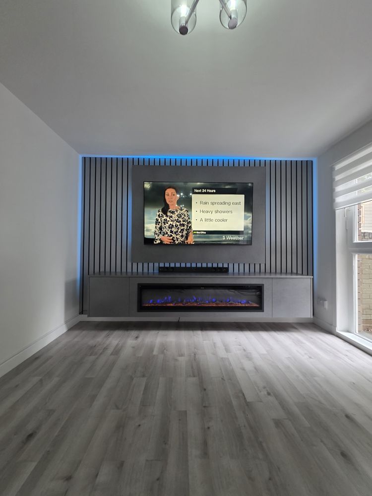 Cubanite grey concrete media wall in Glasgow with charcoal slats, blue LED backlighting and a blue-flame electric fire, by MPS Media Walls.