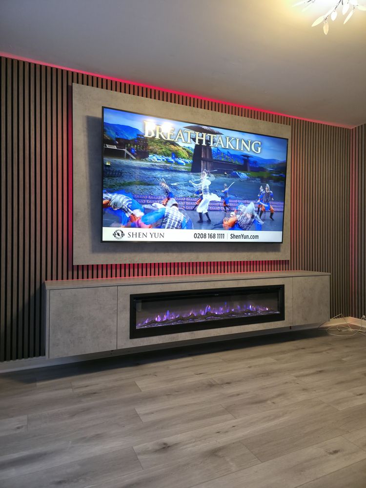 Side angle of a light grey Chicago concrete media wall in Greenock, walnut slats, red LED and purple-flame electric fire, by MPS Media Walls.