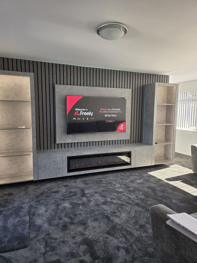 Light grey Chicago concrete media wall in Irvine with charcoal slat panel, mounted TV and wide black electric fire, by MPS Media Walls