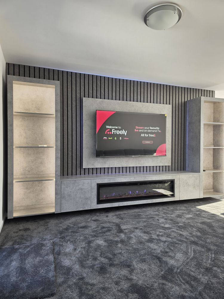 Irvine light grey Chicago concrete media wall with tall open display cabinets and cool blue LED backlighting either side, by MPS Media Walls