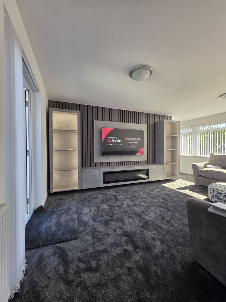 Irvine living room with light grey Chicago concrete media wall, charcoal slat panelling, electric fire and dark grey carpet, by MPS Media Walls