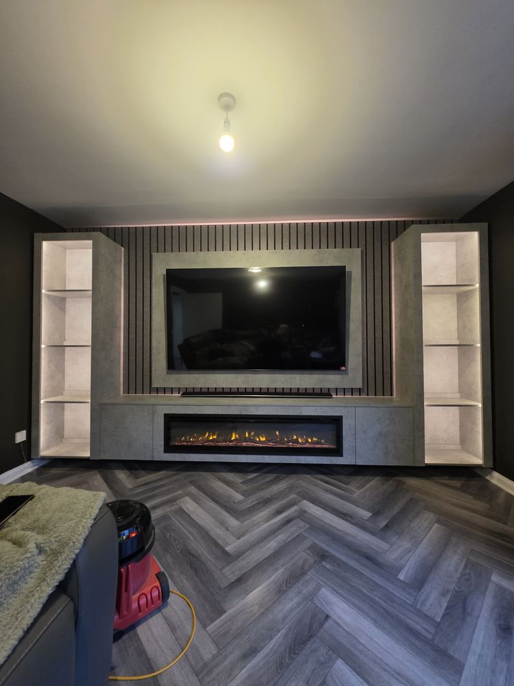 Paisley light grey Chicago concrete media wall lit with pink LED, flanking display units and a glowing wide electric fire, by MPS Media Walls