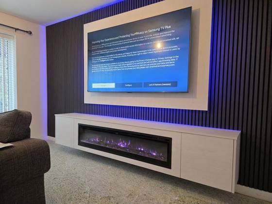 White floating media unit with electric fire and blue LED backlit slat wall