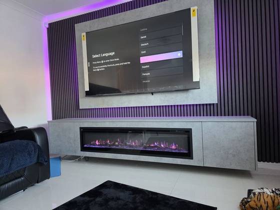 Concrete-effect floating cabinet and dark slat wall with purple LED backlighting