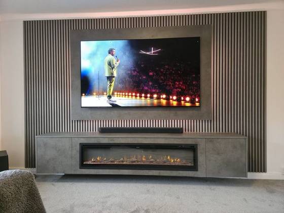 Oak slat media wall with concrete-effect panel, soundbar and long linear fire
