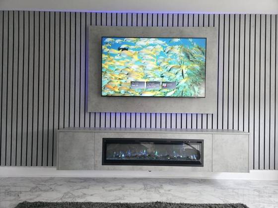 Electric fireplace with TV mounted above on a media wall