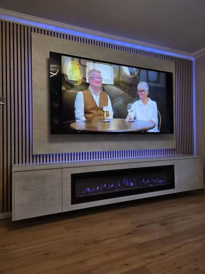 Oak slat media wall with stone-effect panels, blue-flame fire and LED glow