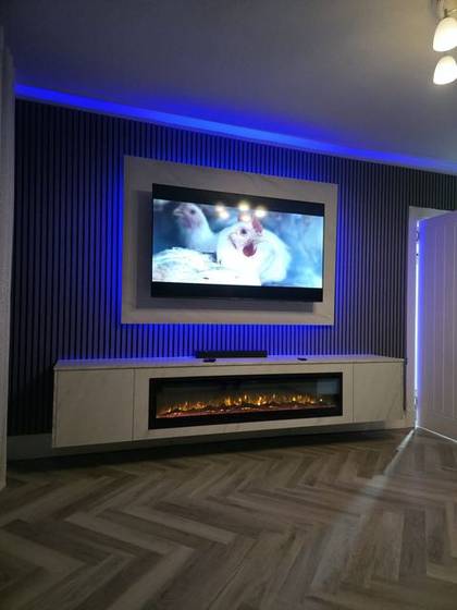 Dark slat media wall with vivid blue LEDs and white marble fire column