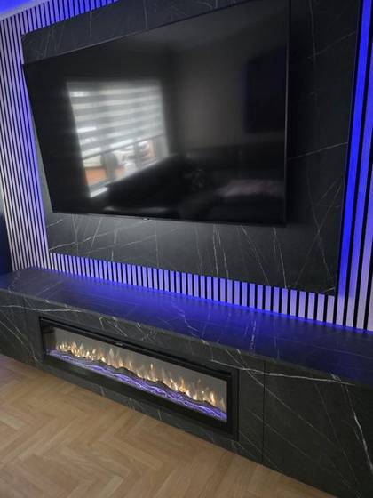 Close-up of black marble media wall with white slats and blue LEDs