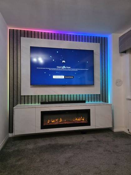 Marble slat media wall with rainbow LED backlighting and amber log fire
