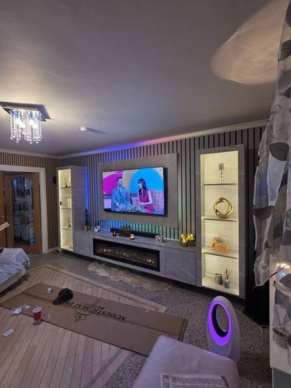 Marble media wall with lit display niches, vertical fire and gold accents