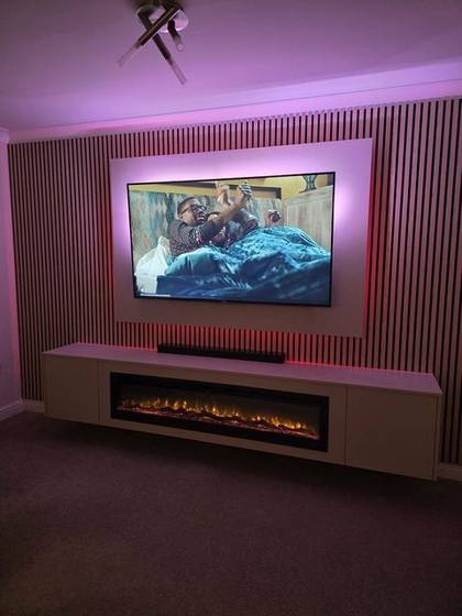 Cream slat media wall glowing pink with soundbar and log-effect fire