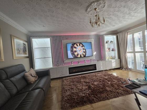 Marble-effect media wall with pink LED lighting, display shelves and linear fire