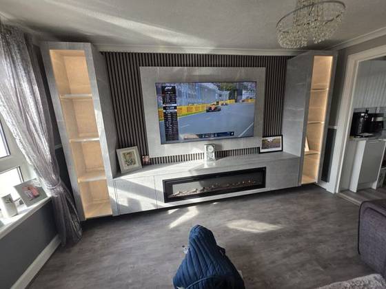 Stone-effect media wall with slatted backdrop, illuminated shelving and inset electric fire