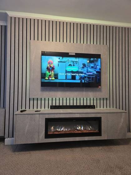 White slat panel media wall with TV, soundbar and log-effect fire