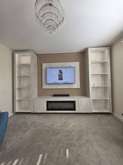 Cream media wall with oak slats, open shelving and inset electric fire