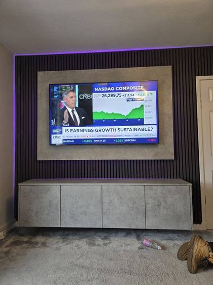 Dark slat media wall with purple LED glow, concrete-effect panel and cabinet