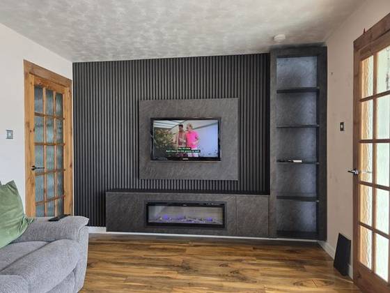 Charcoal slat media wall with open shelving and blue-flame electric fire