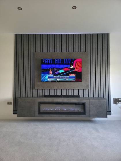 Grey slatted media wall with wall-mounted TV and tall crystal electric fire